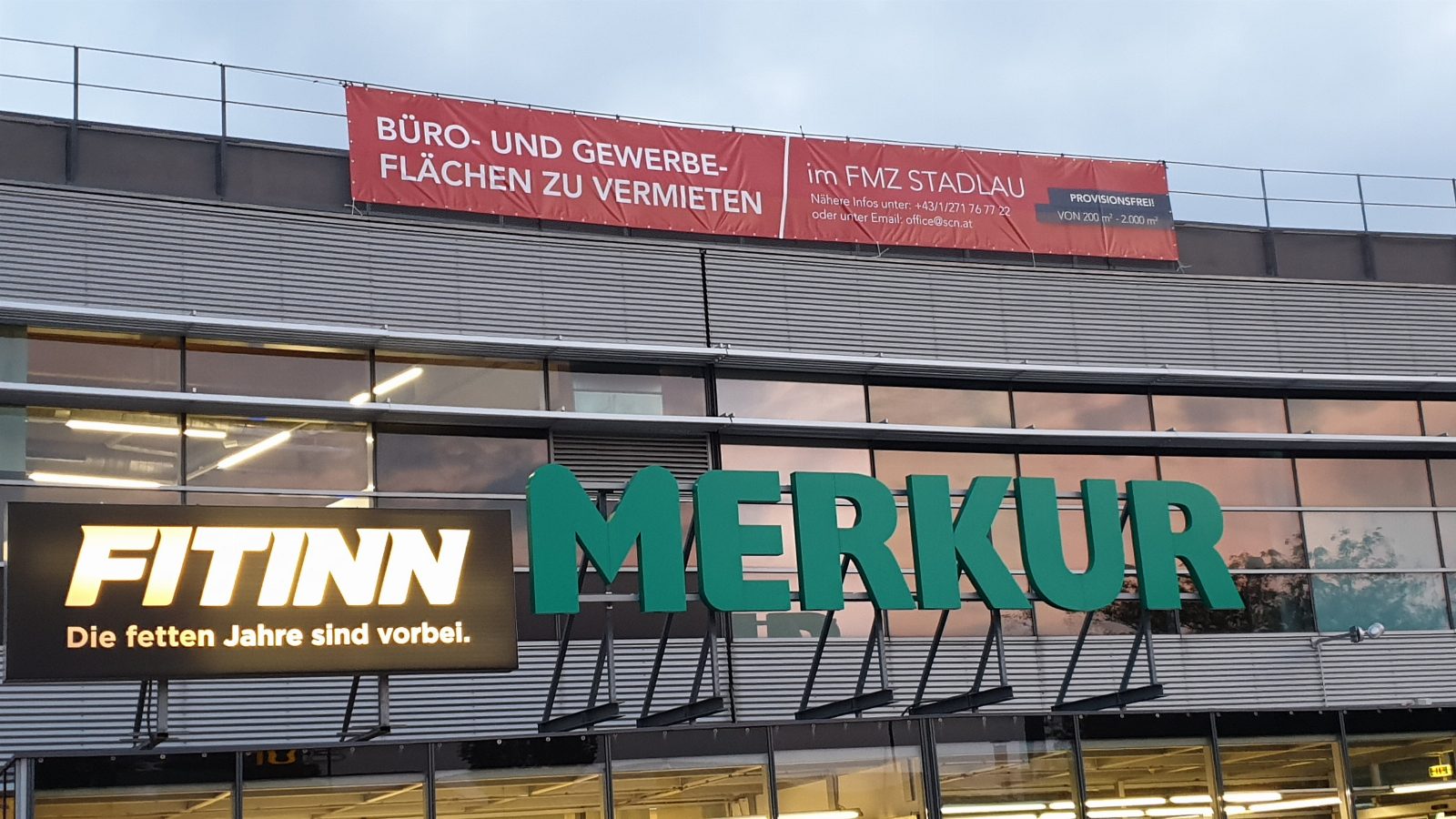 Großformatiger PVC-Werbebanner an Einkaufszentrumsfassade montiert – Beispiel Außenwerbung AbdeX