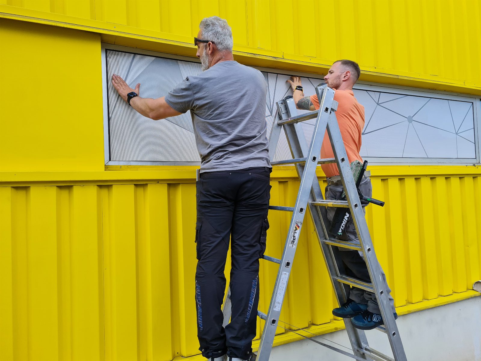 Montage von Sichtschutzfolie mit geometrischem Muster auf Fensterband – AbdeX Werbetechnik Österreich