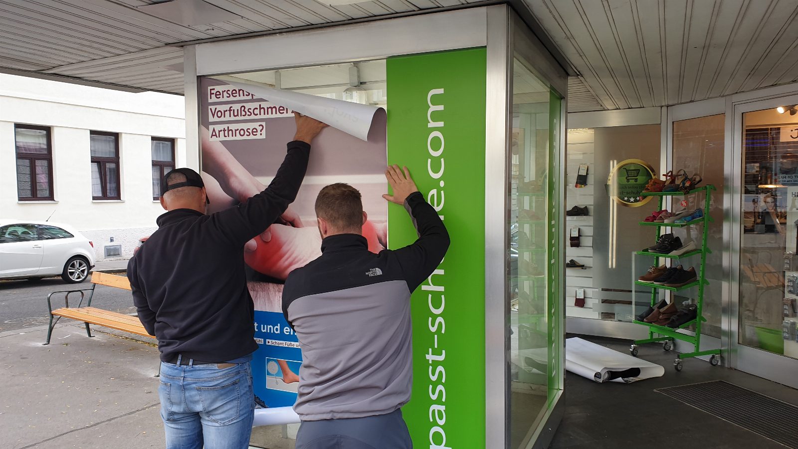 Schaufensterbeschriftung mit Werbefolie – Montage an Glasfassade eines Schuhgeschäfts